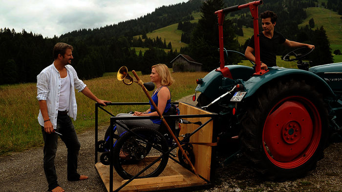Da Wim (Niklas Nißl) in seinem Alter nur Traktor fahren darf, hat sich Pirmin (Philipp Hochmair) zum Transport von Bärbel (Jennifer Ulrich) und ihrem Rollstuhl etwas einfallen lassen. Bild: Sender