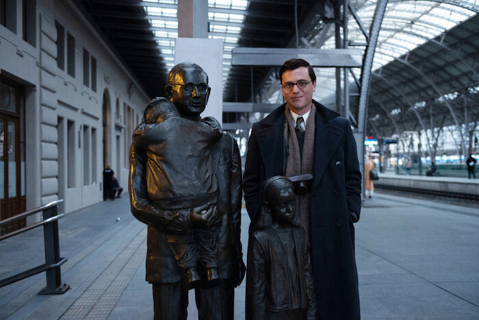 One Life - Wer ein Leben rettet, rettet die ganze Welt: Schauspieler Johnny Flynn in seiner Rolle als Nicholas Winton neben dem Denkmal für Nicholas Winton am Prager Hauptbahnhof. Bild: Sender /  ZDF / JULIE VRABELOVA. 