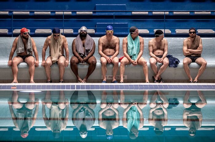 Ein Becken voller Männer:  Die Synchronschwimmer am Beckenrand: Alban Ivanov, Jean-Hugues Anglade, Balasingham Thamilchelvan, Philippe Katerine, Benoît Poelvoorde, Mathieu Amalric und Guillaume Canet. Bild: Sender / rbb / Studiocanal / Mika Cotellon